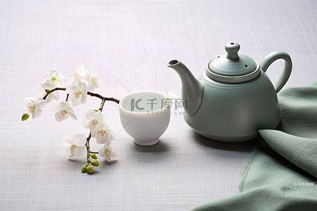 桌上有花的白色和绿色茶壶