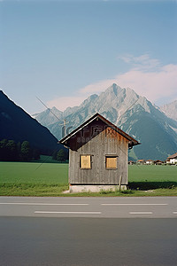 包扎方法背景图片_一条小路上的一座木屋的图像，后面有山