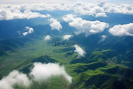 绿色稻田背景图片_鸟瞰山区绿色稻田上空的云彩