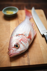 一张鱼坐在刀旁边的木桌上的照片