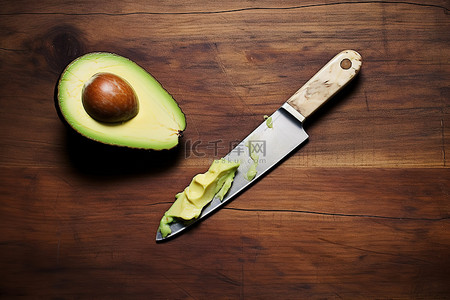 鳄梨和木桌上的一把刀