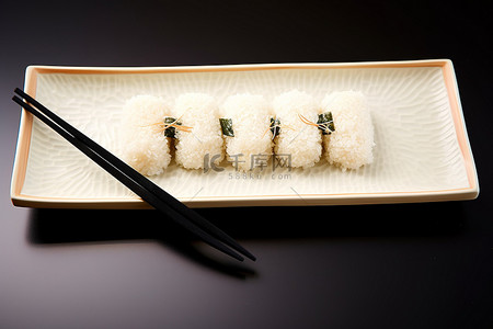 一个小托盘，里面有寿司米饭和筷子