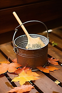 秋天背景图片_一个装有树叶和耙子的桶