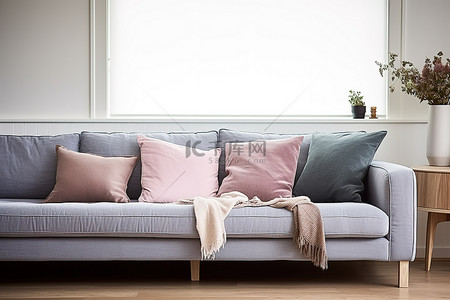 客厅里有一张沙发，配有灰蓝色和粉色的枕头