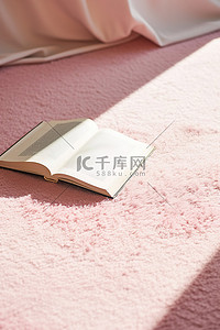地板上粉红色地毯上有一本新书