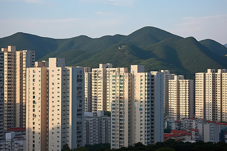 天空山脉背景图片_一些高层公寓楼聚集在山附近