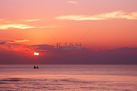 橙色夕阳下两个人在水中骑行