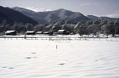 村庄规划背景图片_山和房屋附近的雪覆盖的田野