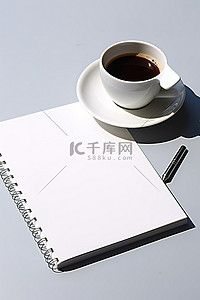 咖啡钢笔背景图片_桌上放着一杯空的白色笔记本咖啡和笔