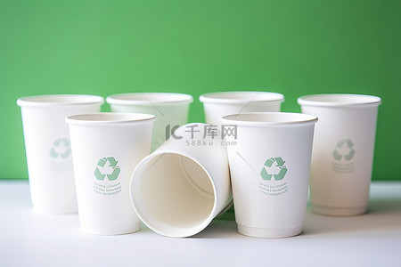 四个不同的纸杯，带有回收标志