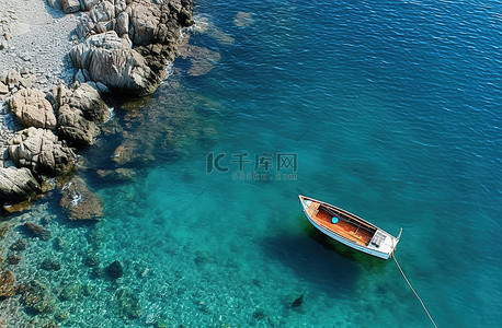岸上的波妞背景图片_一艘蓝色的船停在岩石海岸上，坐在船甲板上