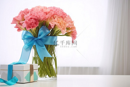 一瓶鲜花放在蓝色和粉色丝带礼物旁边