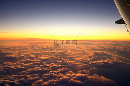 拍背景背景图片_从飞机上看云层上美丽的日落
