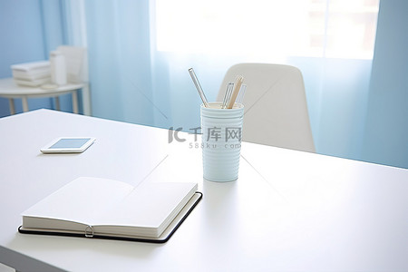 这间白色宿舍间的工作桌上放着笔记本和笔