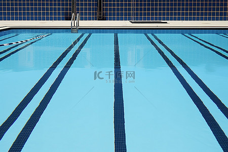 游泳池瓷砖背景图片_一个空的游泳池，有黑线和蓝色瓷砖