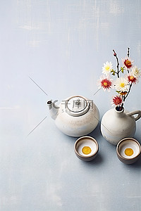 凉茶壶背景图片_背景前桌子上的两个茶壶和鲜花