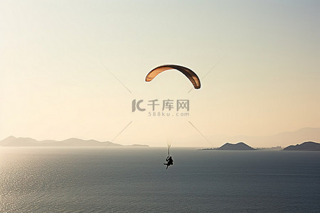 滑翔伞手绘背景图片_滑翔伞越过海湾的海洋的人