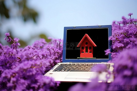 小笔记本电脑，上面有一个小鸟屋，上面有一朵紫色的花