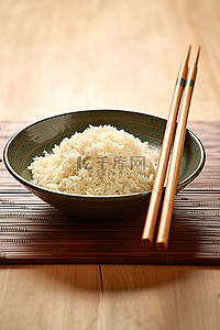 餐具筷子背景图片_木桌上盘子里的米饭和筷子