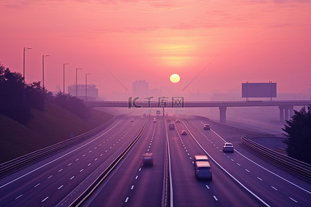 早晨的太阳背景图片_太阳从高速公路上冉冉升起，车辆驶过