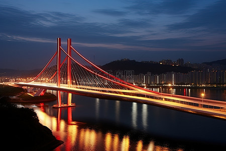 天空水面背景图片_夜间交通繁忙的桥梁横跨水面