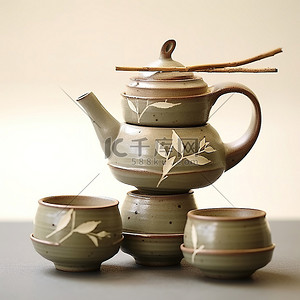 茶具茶具logo背景图片_四个灰绿色的茶壶和杯子堆叠在一起