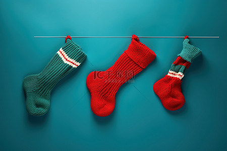 毛主度的袜子背景图片_蓝色表面上的三只针织袜子