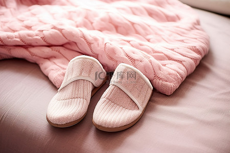 粉色拖鞋和带有绞花针织毛衣的毛衣坐在粉色地毯上