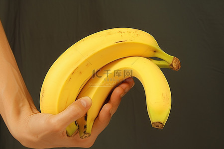 剥香蕉背景图片_一个人拿着一根一侧被切掉的香蕉