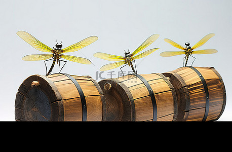 三个小蜻蜓雕像坐在木桶上