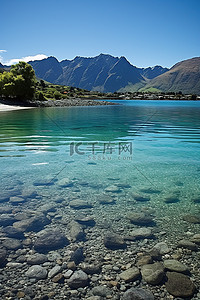 水清澈背景图片_靠近山的岩石海滩，水清澈