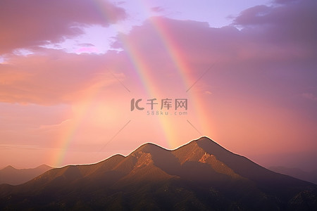 山上有两条彩虹，前景中有两个山顶