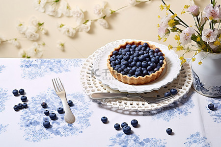 一捆东西背景图片_桌上放着蓝莓馅饼，上面放着鲜花和其他东西