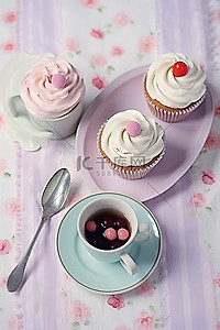 地摊奶茶背景图片_一杯茶纸杯蛋糕和放在桌布上的盘子