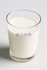 牛奶在一个白色表面的玻璃杯中