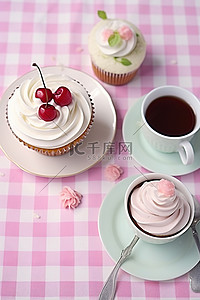 一杯茶纸杯蛋糕和放在桌布上的盘子