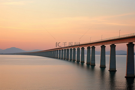 长的背景图片_香港日落时横跨海洋的一座很长的桥