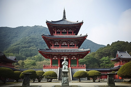 一座古老的红色宝塔，前面有高大的雕像