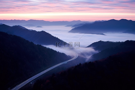 山路背景图片_山中的一条山路和有光的雾