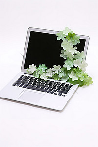 绿叶装饰着一台白色笔记本电脑