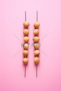 粉红色背景中带筷子的坚果