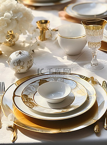 桌子上放着金色和白色的盘子银器和水晶