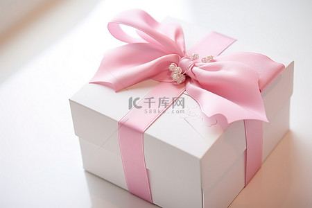 盒子粉色背景图片_一个白色盒子，上面有一条粉红色丝带和一个标签