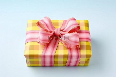 一个长方形的盒子，上面覆盖着黄色和粉色的格子丝带