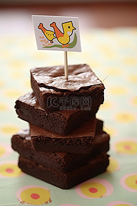 贴纸特效背景图片_一堆布朗尼蛋糕，上面贴着快乐纸杯蛋糕贴纸