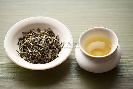 陈年绿茶背景图片_桌上的碗里盛着白茶和绿茶