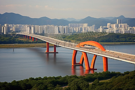 国际的背景图片_韩国的橙色铁路桥横跨水面城市和山脉