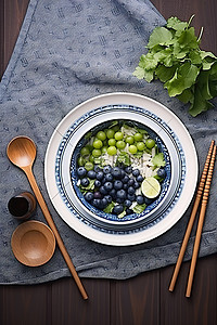 桌子上的米饭上有一系列蔬菜和蓝莓，而沙拉碗则在上面