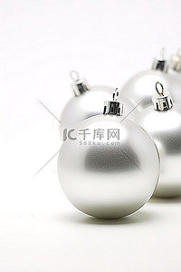 圣诞节色背景图片_白色背景上的三个银色圣诞饰品