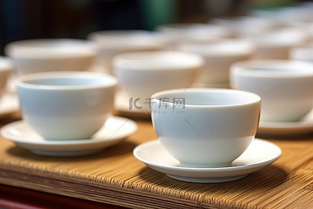 茶具茶具logo背景图片_雨伞前放着一张桌子，上面有许多白色杯子